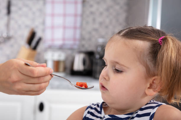istock Mother's Hand Feeding Tomato Slice To Her Daughter 1134962202