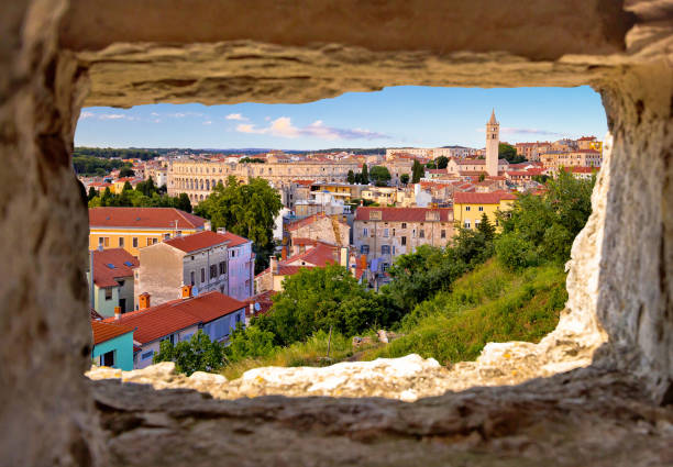 panoramablick auf pula wahrzeichen durch steinfenster - amphitheater pula stock-fotos und bilder