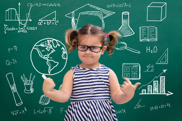 istock Girl Pointing Educational Symbols On Green Chalkboard 1134962279