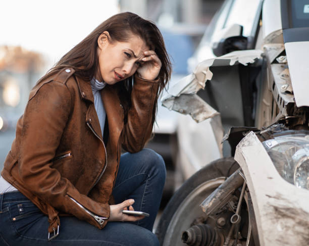istock Young desperate woman next to a crashed car. 1134963739