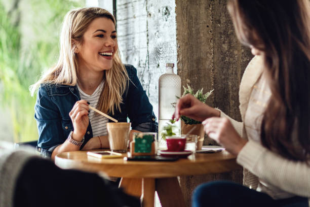 istock Two young women drinking coffee and having fun in a cafe. 1134967774
