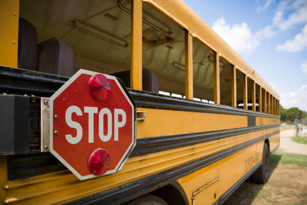 красный знак остановки с огнями на стороне старого желтого школьного автобуса. вернуться в школу - on wheels flash стоковые фото и изображения