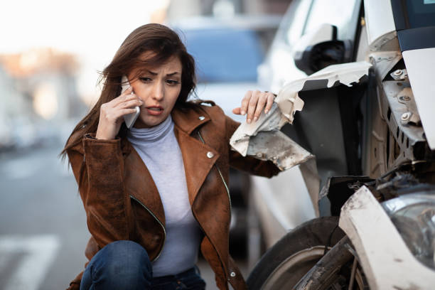 istock Sad woman calling roadside assistance after a car crash. 1134969025
