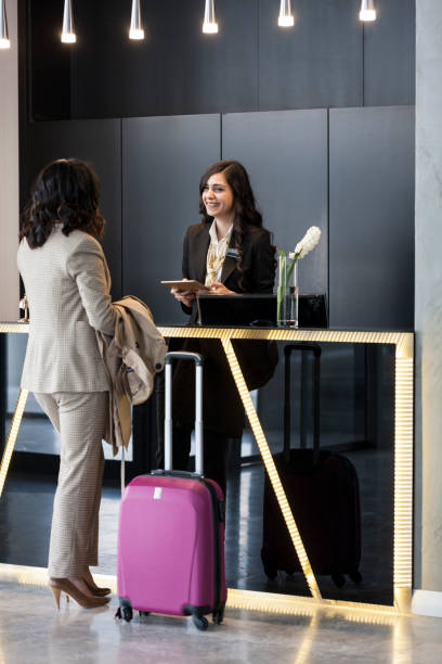 Businesswoman Checking In At Hotel Reception