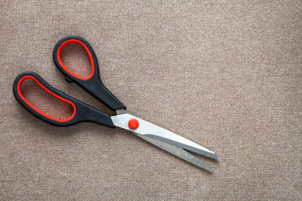 istock Close-up of sharp steel metal scissors isolated on light cloth copy space background. Household equipment, office or school tools. 1134975192