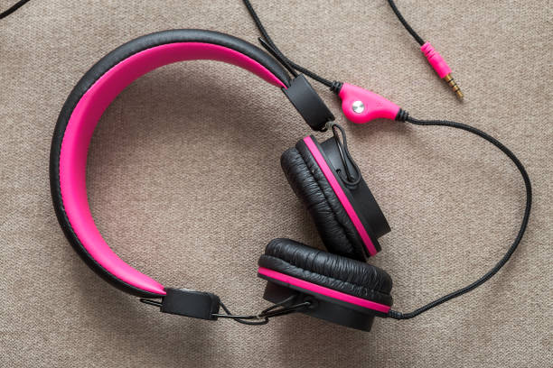 istock Headphone black and pink isolated on light cloth flat copy space background. Modern technology, trendy entertainment, gadget design and accessories concept. 1134975203