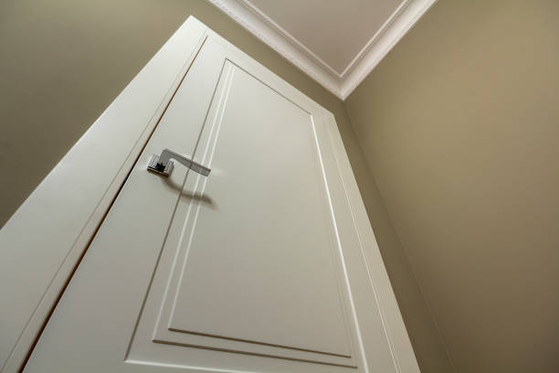 istock Apartment after renovation interior. White door with metal handle, light walls and ceiling, angle view. 1134975232
