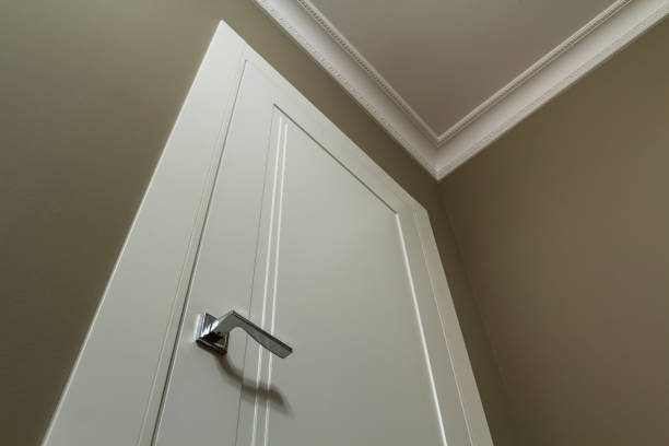 istock Apartment after renovation interior. White door with metal handle, light walls and ceiling, angle view. 1134975251
