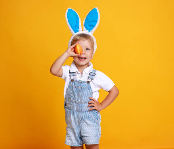 istock funny happy child boy with easter eggs and bunny ears on yellow 1134978219