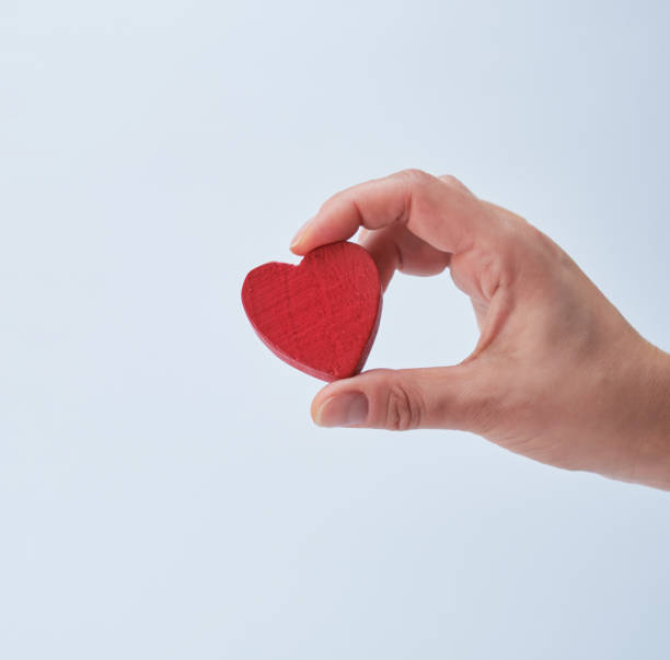 istock red heart in a human hand on a white background 1134981733