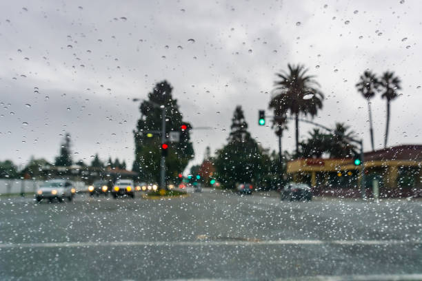 istock Raindrops on the windshield on a rainy day, traffic light background 1134981769