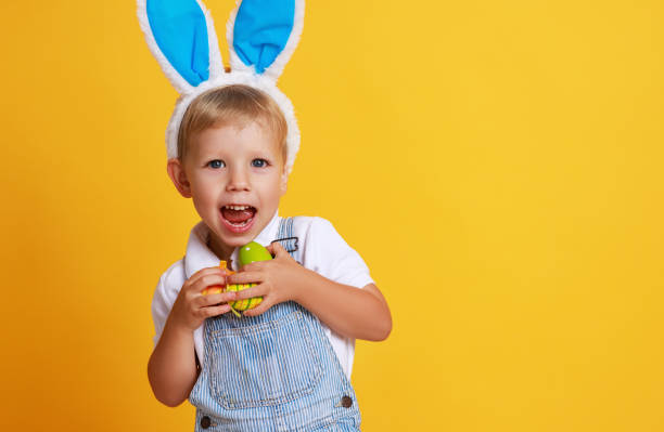 istock funny happy child boy with easter eggs and bunny ears on yellow 1134981803