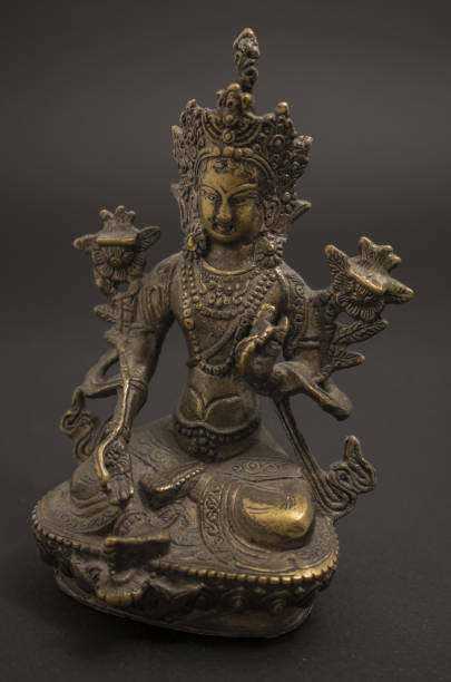 istock Tibetan Buddhism: Green Tara brass sculpture isolated on dark background. 1134984208