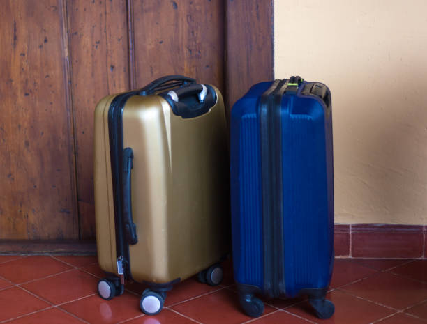 istock On Vacation: Two Wheeled Suitcases Outside Door 1134984283