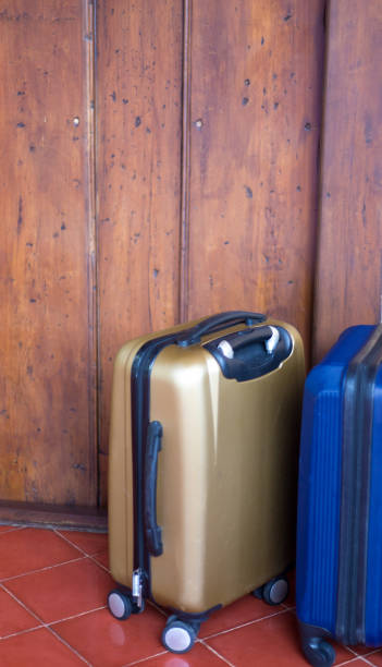 istock On Vacation: Two Wheeled Suitcases Near Door 1134984394