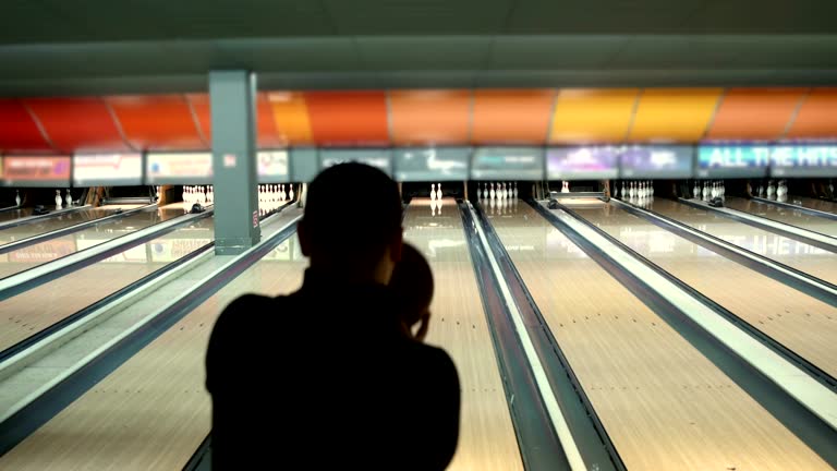 Man  throws up ball on skittles in bowling club