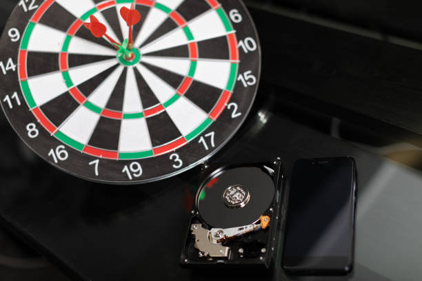 istock Winchester with mobile phone and Darts at targets on dark background 1134996941