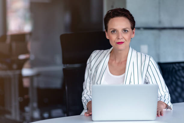istock Beautiful business lady with laptop computer in office. 1134997125