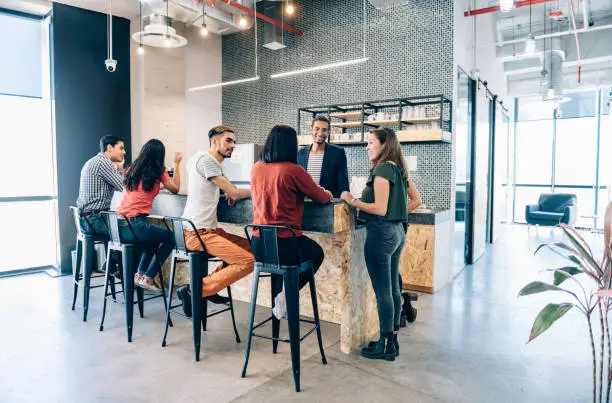 Business team during casual conversations at coffee break in co-working office