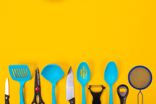 Kitchen utensils isolated on yellow background