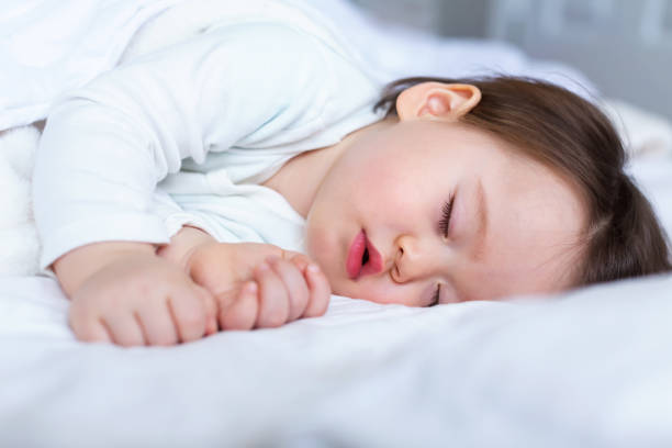 Sleepy toddler boy sleeping Sleepy toddler boy sleeping on his bed baby sleeping bedding bed stock pictures, royalty-free photos & images