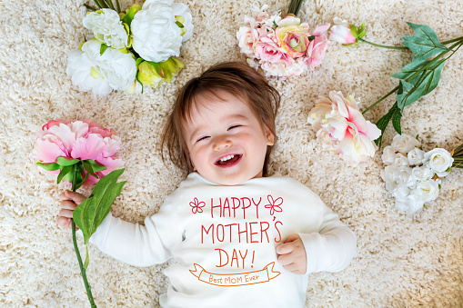 Mother's Day message with happy toddler boy with spring flowers