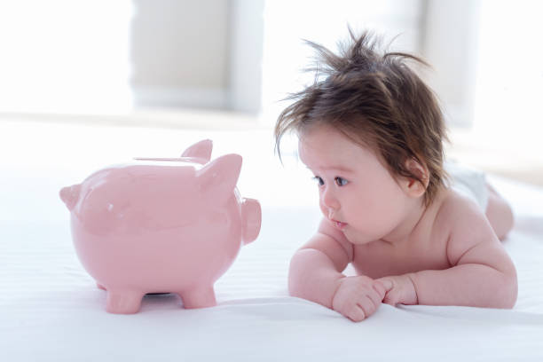 Baby boy with a piggy bank stock photo