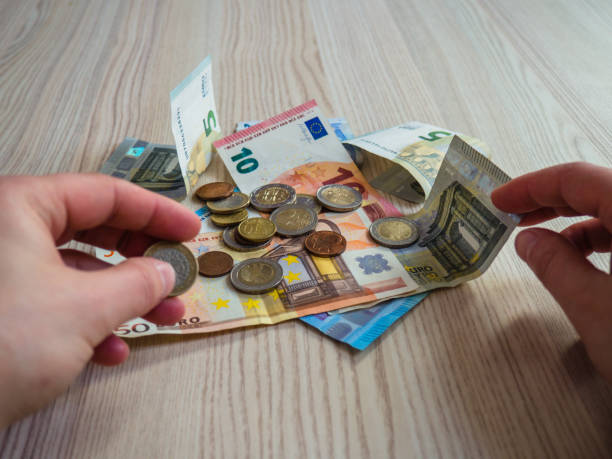 istock Hands taking euro banknotes and coins 1134999699