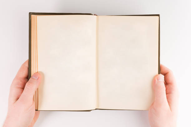 istock Overhead view of hands holding a blank book ready for text, isolated on white background 1135000991