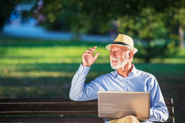 istock Senior man using laptop computer at rest in the park outdoors 1135009179