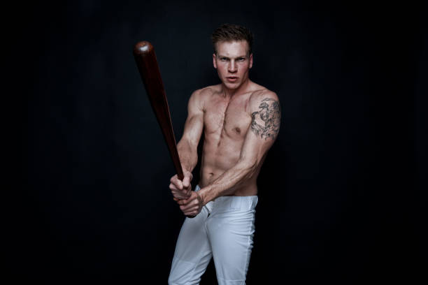 istock Sexy baseball player on black background 1135016150