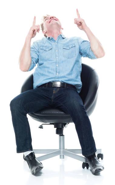 istock Happy man seated and looking up and pointing 1135019884