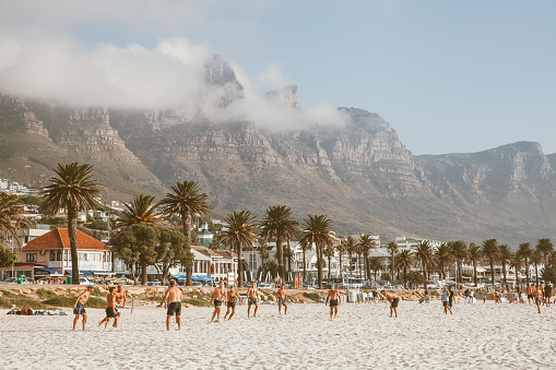 6th March 2019, Cape Town,South Africa: Tourists enjoying the white beach and sun bathing at camps bay in Cape Town,South Africa. Camps Bay is an affluent suburb of Cape Town. Twelve Apostles mountain range in background.