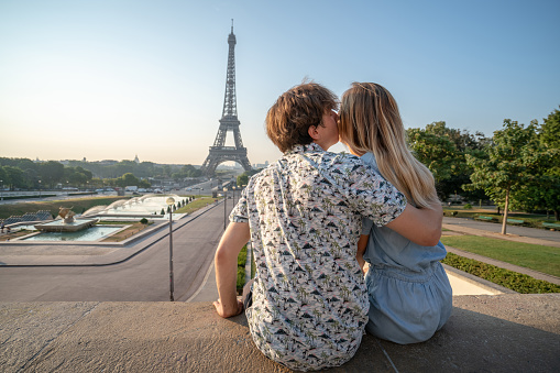 Young couple at the Eiffel Tower in Paris contemplation the urban skyline People travel discovery city concept\nYoung caucasian woman tourist in Paris