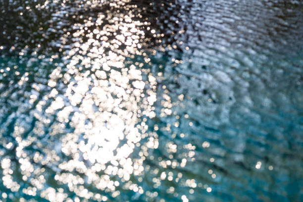 Vigie Beach, Castries, Saint Lucia, West Indies: Sun rays reflected on a water surface with small waves - small stars formed by sunlight reflection - high contrast.