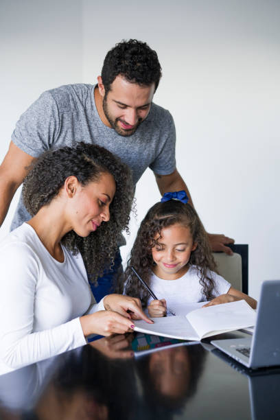 istock Girl doing homework with the help of her parents 1135030179