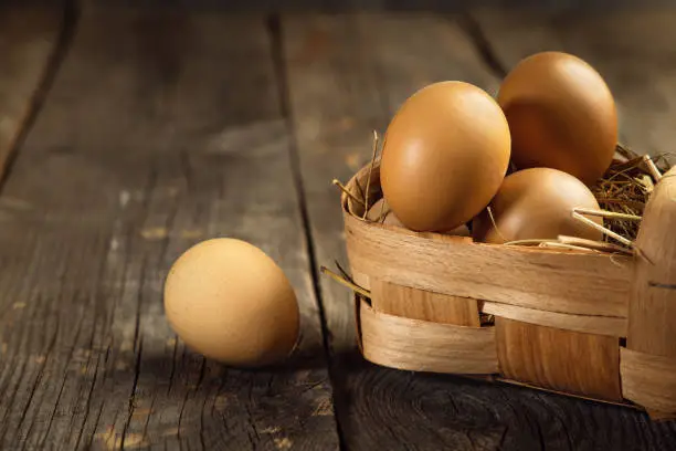 Fresh brown eggs on a wooden table, copy space