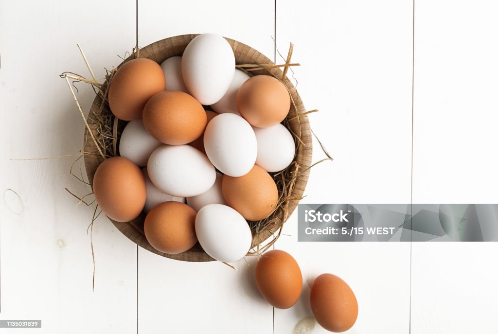 Eieren in doos container op een witte houten lijst. Bovenaanzicht - Royalty-free Dierenei Stockfoto