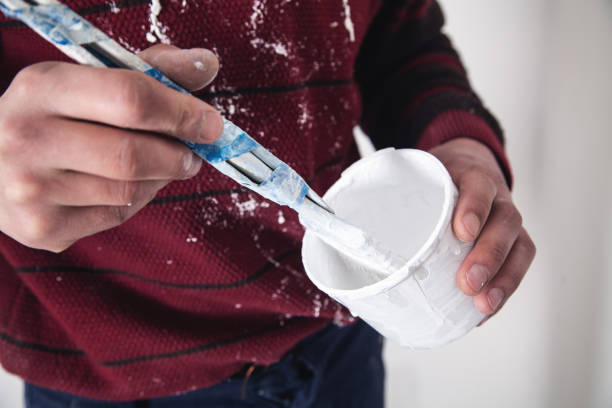istock Man hands paintbrush with white paint. Renovation 1135032784