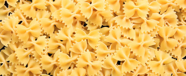 istock Uncooked farfalle bow shape pasta texture background, banner 1135032847