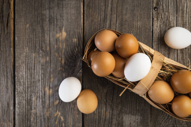 istock Fresh eggs on a wooden table, top view 1135032908
