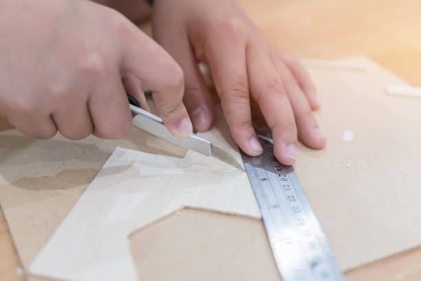 istock Close-up Student hands using knife cutter Ruler metal material, cutting create works through wood 1135033909