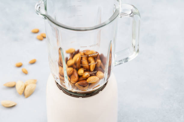 Blender with soaked almonds for making nut milk. Dairy free, no lactose vegan milk. Step by step recipe.