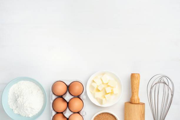 ингредиенты для выпечки и кухонная утварь на белом фоне - baked стоковые фото и изображения