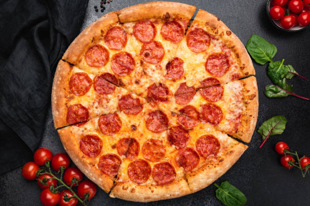 heiße pepperoni pizza auf schwarzem konkretem hintergrund - pepperonipizza stock-fotos und bilder