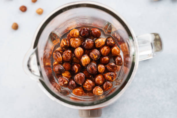 Blender and hazelnuts soaked in water. Making healthy vegan milk Blender and hazelnuts soaked in water. Making healthy vegan milk. Step by step recipe. drenched stock pictures, royalty-free photos & images