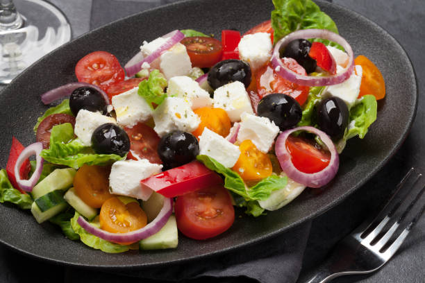 istock Greek salad plate and white wine 1135037564