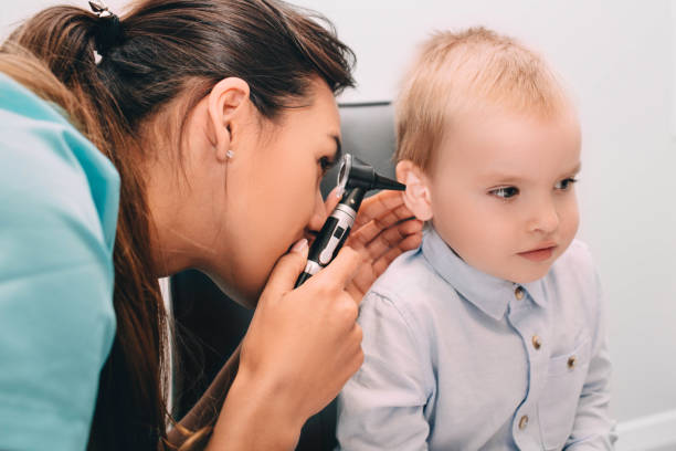 istock Smiling little boy having ear exam with otoscope 1135039723