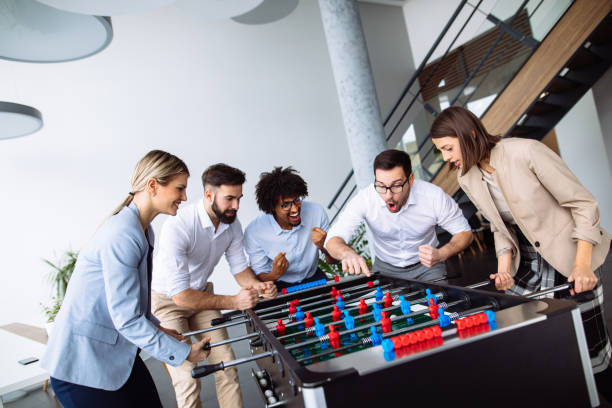 istock Happy young office workers playing table football 1135039847