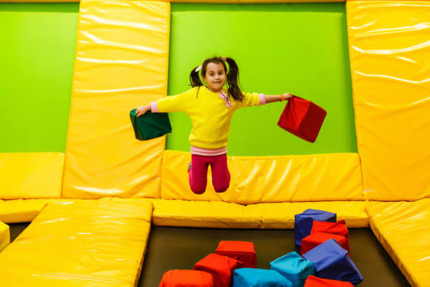 infância feliz de uma criança moderna na cidade-menina que salta no parque do trampoline - trampolim - fotografias e filmes do acervo